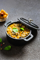Hearty vegan lentil mushroom stew in cast iron pot. Space for text.