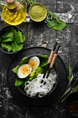 Rice noodles with egg, broccoli and spinach. Asian cuisine. Top view. Free space for your text.