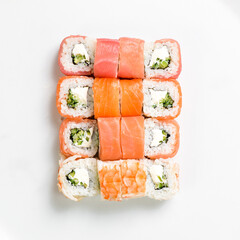 Asian cuisine. Large set of sushi rolls on a plate. Top view. On a white background.