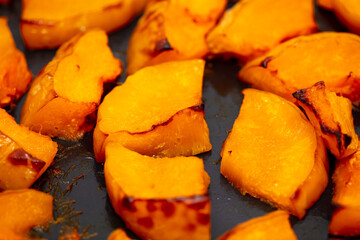 Pieces of pumpkin baked on a baking sheet. Food