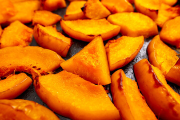 Pieces of pumpkin baked on a baking sheet. Food