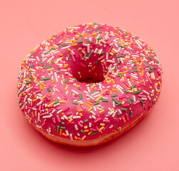 Red donut on a pink background.