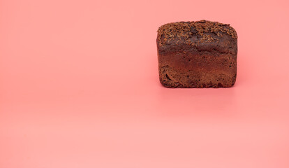 Rye bread sprinkled with cumin seeds on a pink background.