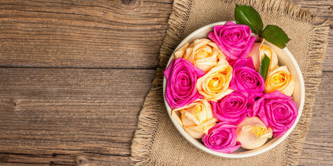 Composition of fresh multicolored roses in ceramic bowl
