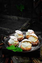 Dessert tasty shu cakes. Candy bar. On a black stone background, top view.
