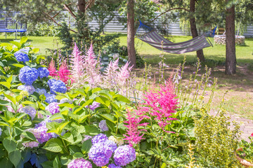 Garden yard design. Beautiful landscape with garden corner. Blooming flowers background