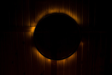 A black circle with a glow. An abstraction with a black circle and light. The silhouette of a black chandelier on the ceiling with a halo of light around.