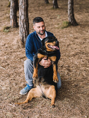 Fototapeta premium Hombre jugando con su perro rottweiler en el parque