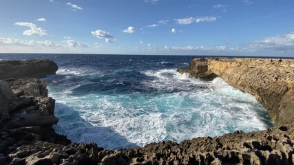Waves crashing on rocky coastline of Gozo, Malta, slow motion