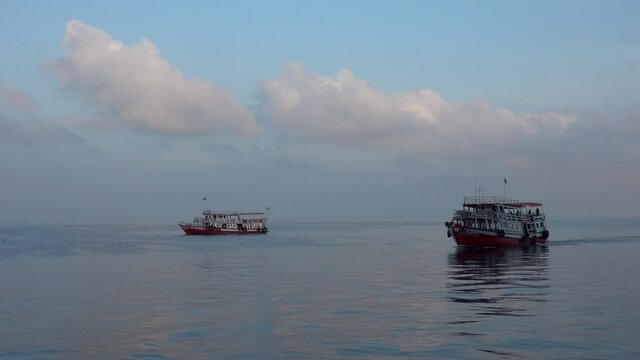 two asian boats floating with different speed.