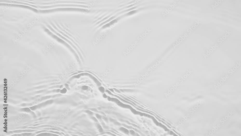 Poster up close, top view, slow motion various waves of the water surface hitting the sun's rays, making th