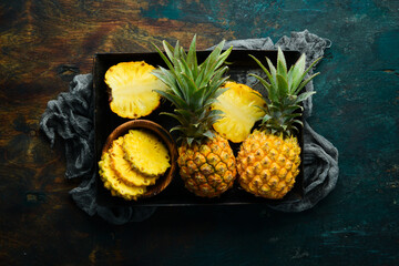 sliced juicy pineapples. Ripe baby pineapple. Tropical fruits. Top view. Free space for text.