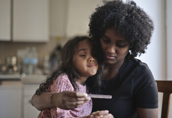 mother feels fever in her daughter