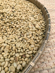 The dried coffee beans on wooden basket