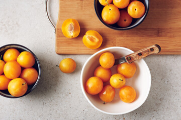 Ripe yellow mirabelle plums in bowls.