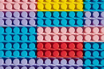 children's play background: the plane of plastic multi-colored bricks, blur, selective focus