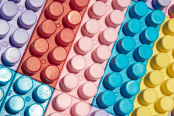 children's play background: the plane of plastic multi-colored bricks, blur, selective focus