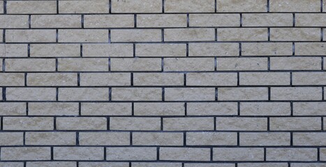 textured street wall made of gray bricks in uneven masonry image full frame, brick surface with a light shade volumetric texture, block empty backdrop graphic resource
