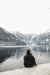 Traveler-Image. Traveler look at the mountain lake in winter. Travel and active life concept. Adventure and travel in the mountains region in the Austria, Hallshtat.