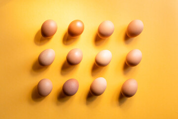 Group of fresh eggs aligned on yellow background. Easter concept.
