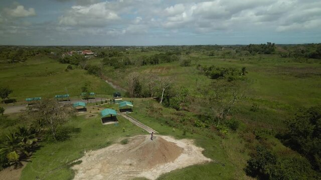 Aerial drone view of a young girl walking around the cone of a mud volcano located in Penal, Trinidad