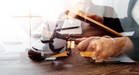 Business and lawyers discussing contract papers with brass scale on desk in office. Law, legal services, advice, justice and law concept picture with film grain effect