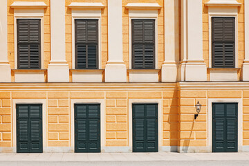 Fototapeta na wymiar Close door and window shutters on the yellow facade