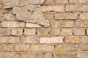 Old wall of bricks with chapped plasterwork.