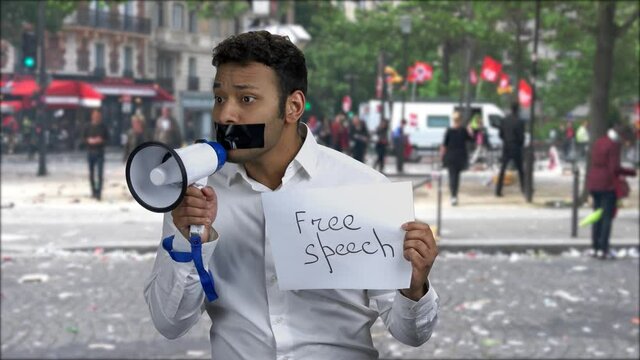 Portrait of male protester with taped mouth.