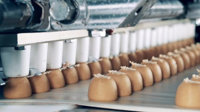 Close up of fudge candies getting produced by an industrial machine
