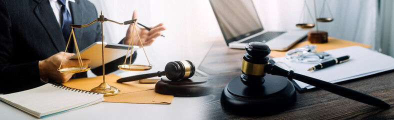 Justice and law concept.Male judge in a courtroom with the gavel, working with, computer and docking keyboard, eyeglasses, on table in morning light