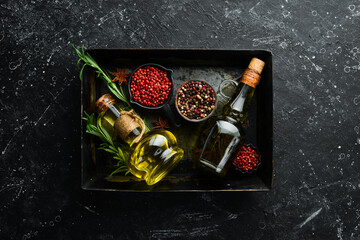 Jar of olive oil with spices on a dark background. Top view. Free space for your text.