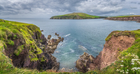 Large panorama with Dingle Lighthouse and bay surrounded by cliffs. Dingle peninsula and Wild...