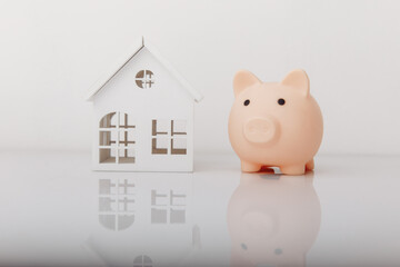 Piggy bank and house model. Savings and banking concept
