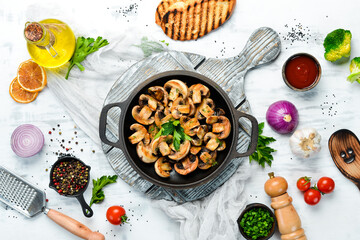 Baked mushrooms in a frying pan. Champignons. Top view. Free space for your text.