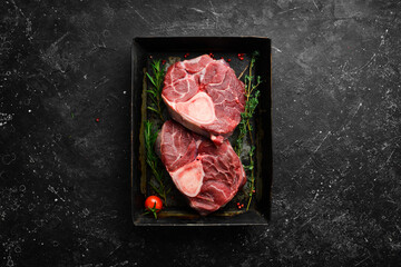 Osso buco Veal steak with rosemary and spices. On a black background. Top view.