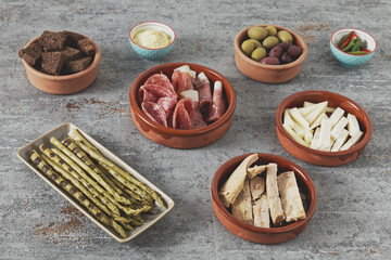 Set of tapas appetizer and snacks prepared at home in ceramic bowls.