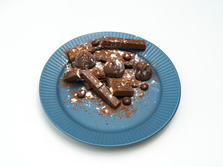Composition of bars and pieces of different milk and dark chocolate, cocoa grater on a white background, top view