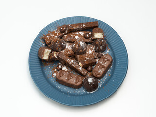 Composition of bars and pieces of different milk and dark chocolate, cocoa grater on a white background, top view