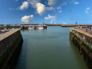 Fototapeta na wymiar Port-en-Bessin-Huppain, France, March 2021. Picture made of sailing channel towards the sea in a picturesque small town in Normandy