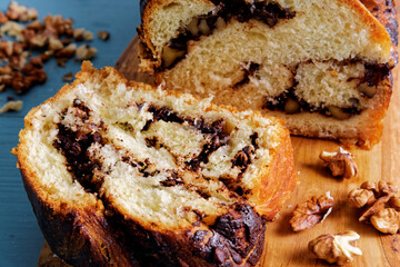 Close-up view of cut piece of Krantz cake with chocolate and nuts filling. Yeast-risen dough braided cake.
