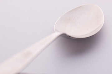 Single table spoon from different perspective on white