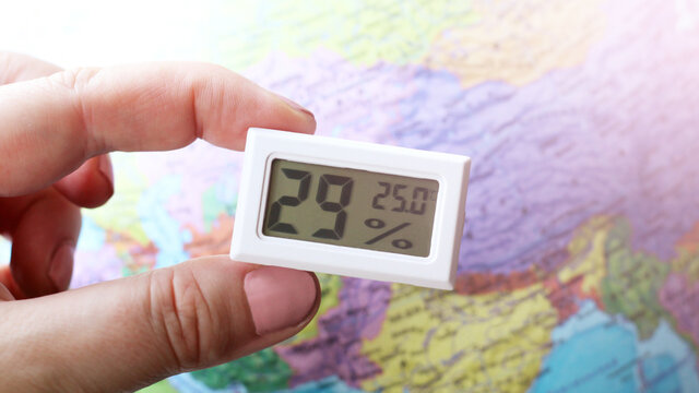 Device for measuring humidity and temperature on the background of the world map, weather forecast
