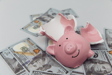 Investment and bankruptcy concept. Broken piggy bank on dollar banknotes