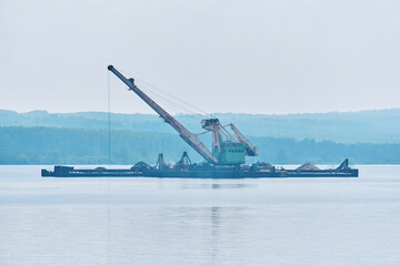 Fototapeta na wymiar dredging boat is working to deepen the fairway on the river