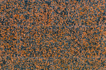 Empty texture of the wall with facing tile of red, spotted, decorative, polished marble with copy space