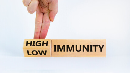 High or low immunity symbol. Doctor turns a block and changes words 'low immunity' to 'high immunity'. Beautiful white background. Medical, high or low immunity concept. Copy space.