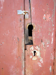 Broken rusty and deteriorated locks on an old wooden door from the 16th century.