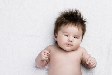A newborn baby lies on a soft towel after bathing. Hygiene of children.