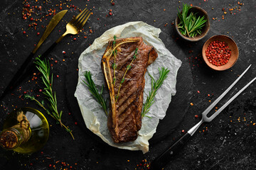 Grilled New York beef steak on the bone, herbs and spices. Juicy cooked steak. Top view. Rustic style. Flat Lay.